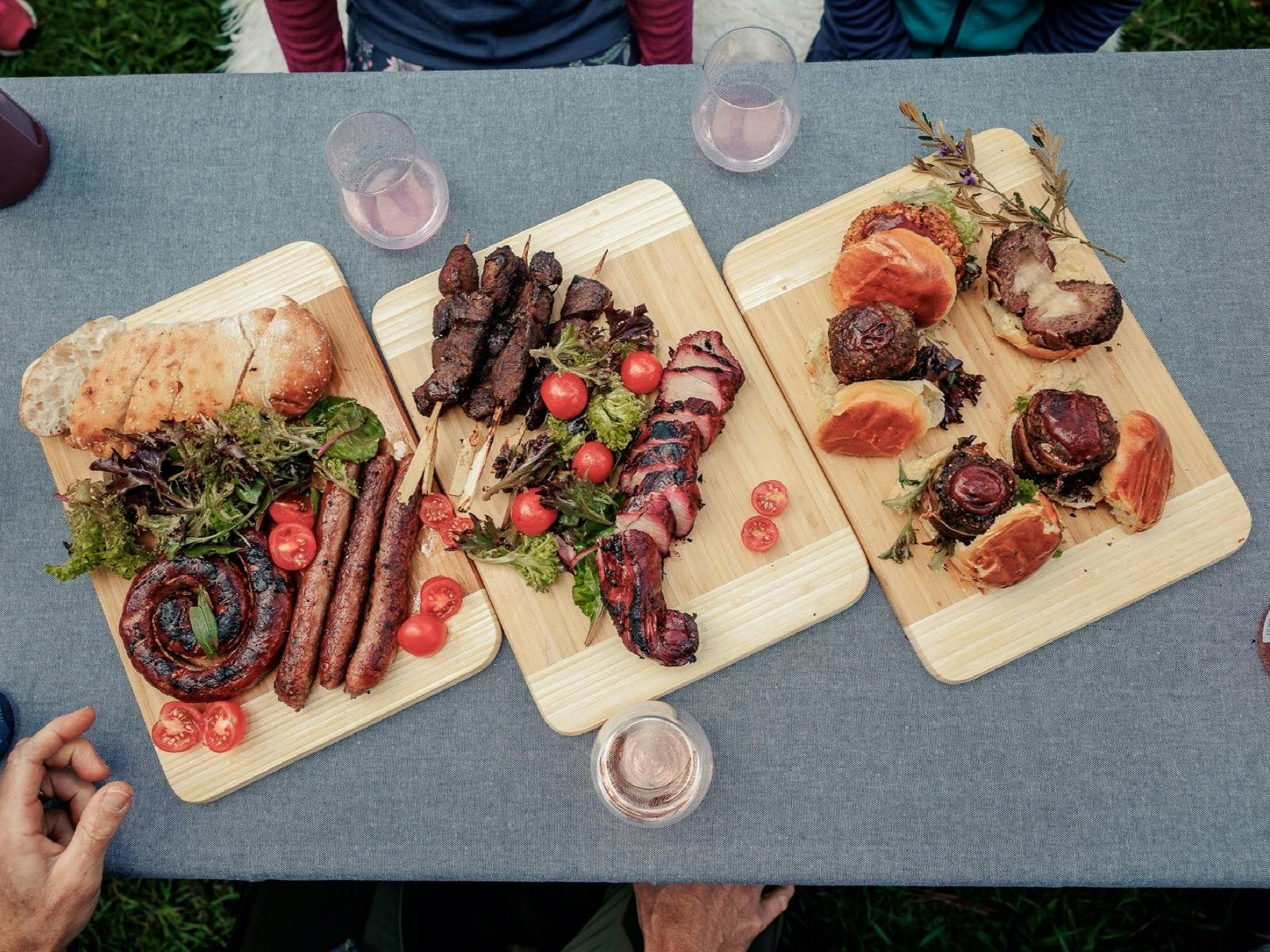 Three wooden trays with assorted grilled meats