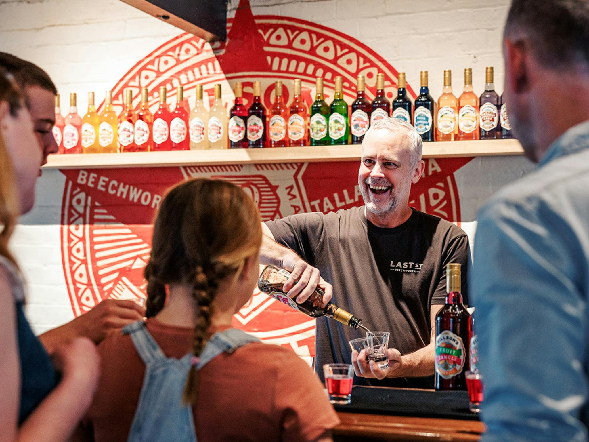 a bartender smiling while pouring drinks at Last St Brewery