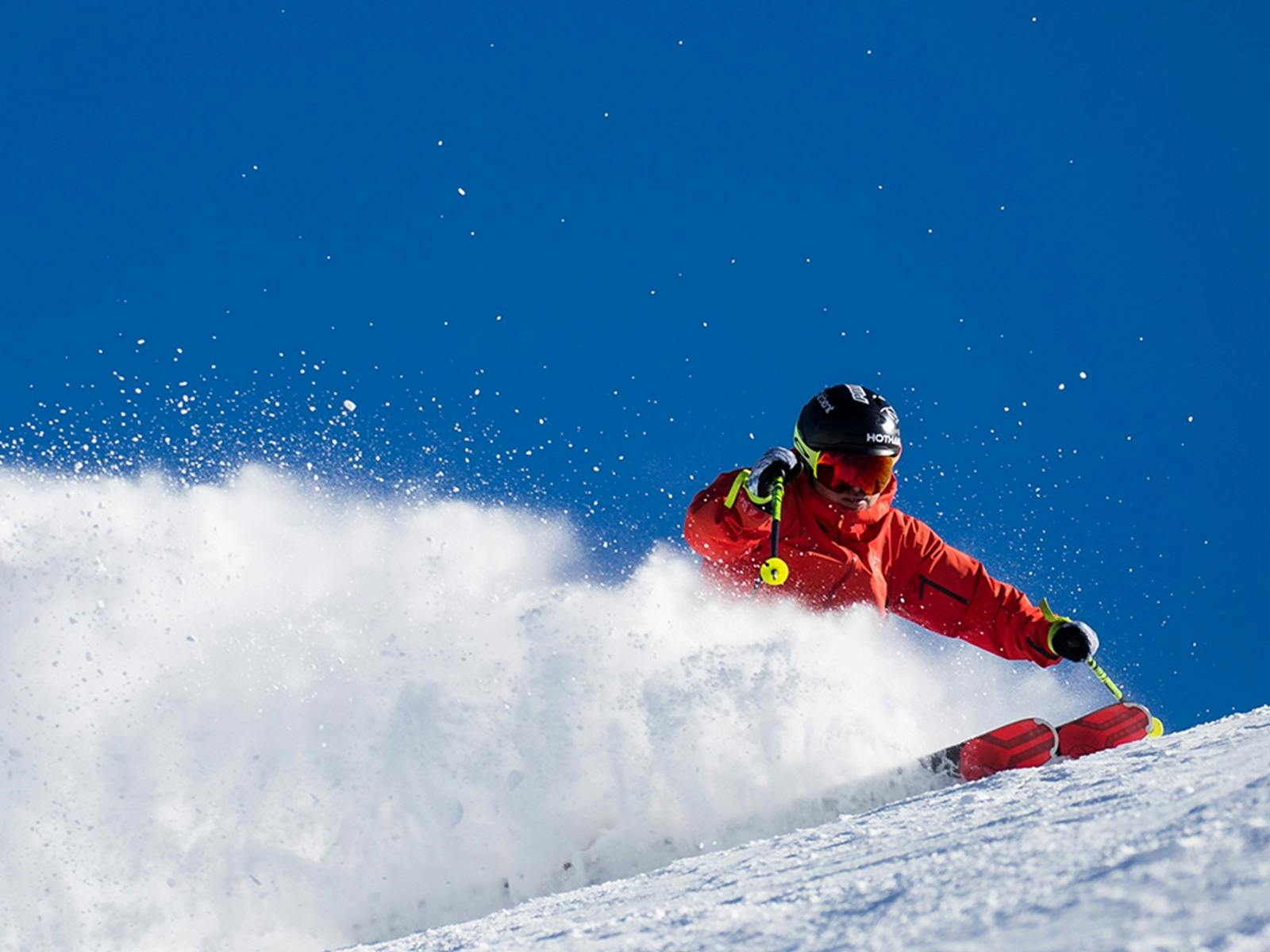 Skier on snow with blue sky
