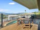 Balcony shot overlooking an outdoor swimming pool and mountains in the background