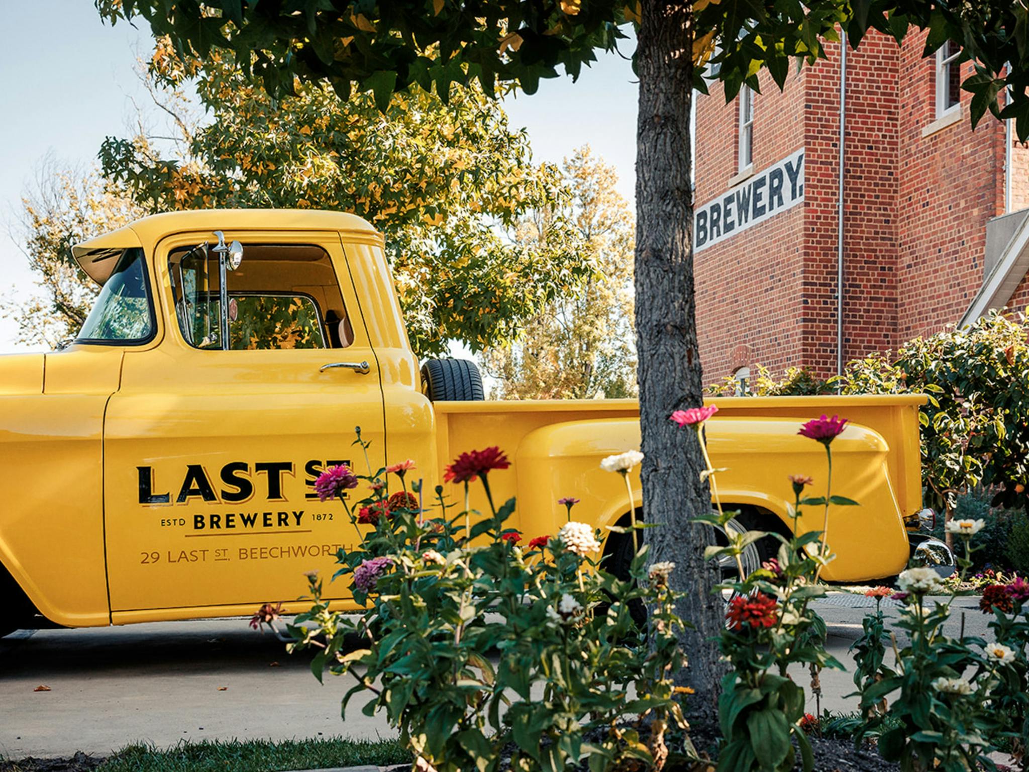 a yellow pickup truck outside Last St Brewery