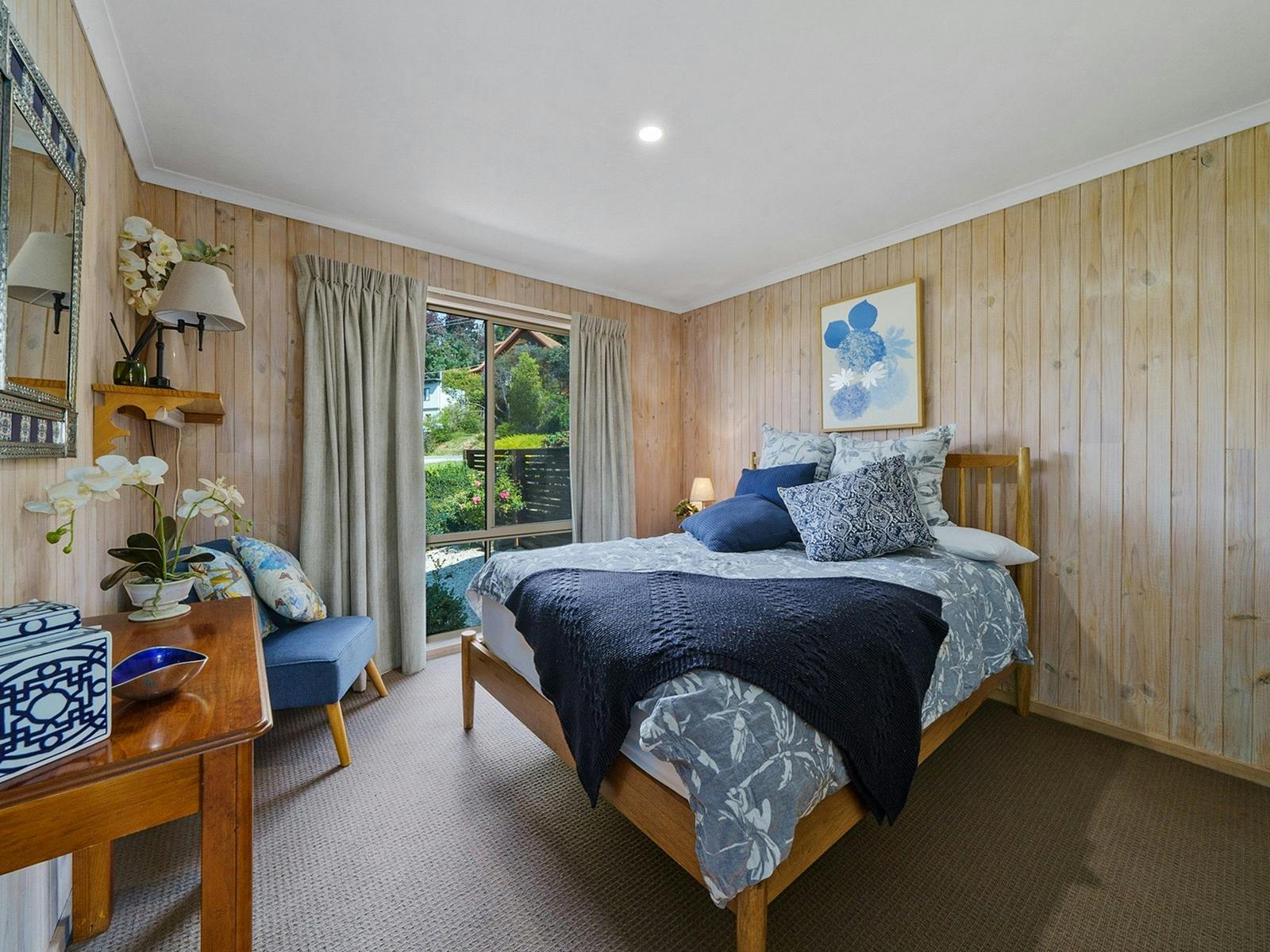 A bedroom with a bed, desk, and chair in the corner