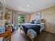 A bedroom with a bed, desk, and chair in the corner