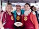 three women posing with food on a plateTrentini delicacy - Strauben