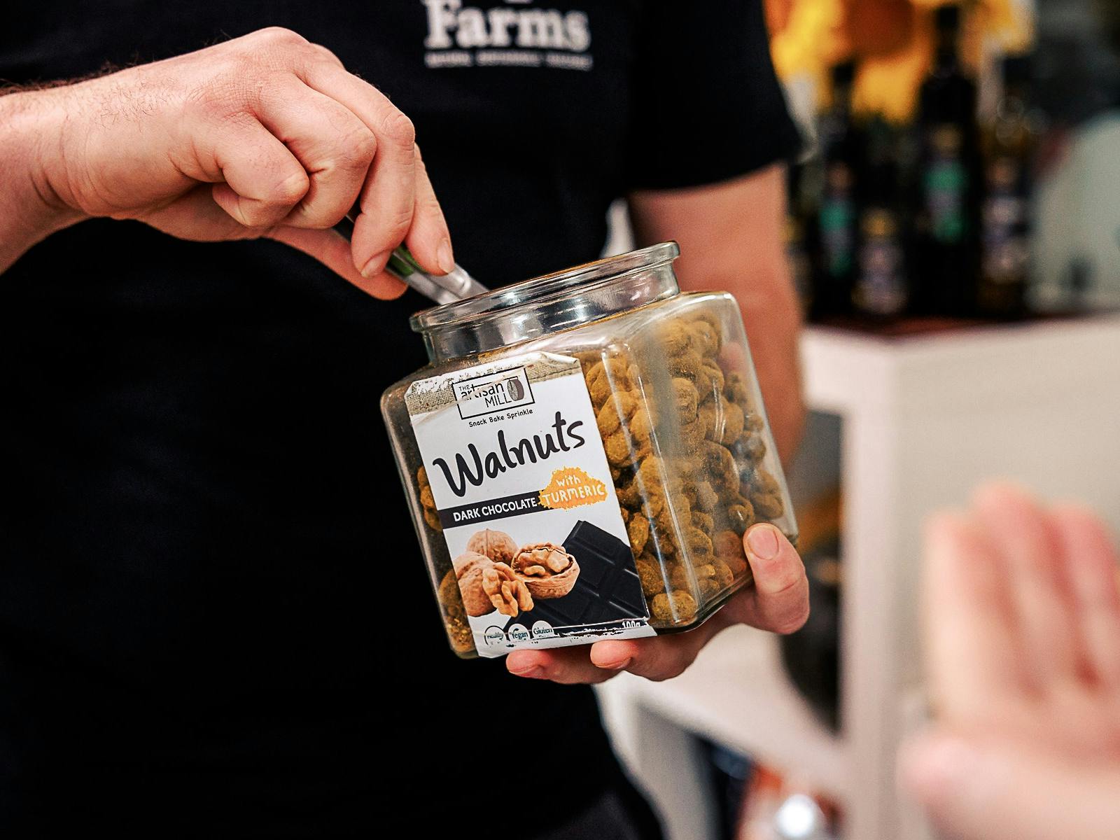 Staff offers a tasting of Pepo Farms’ popular dark chocolate turmeric walnuts in the farm shop.