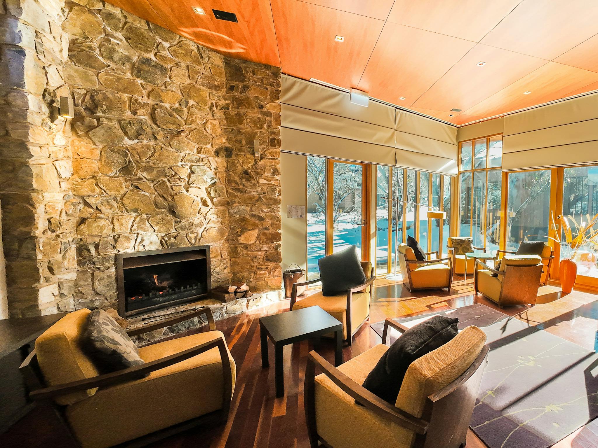 Lounge room with chairs and a stone wall with a fireplace