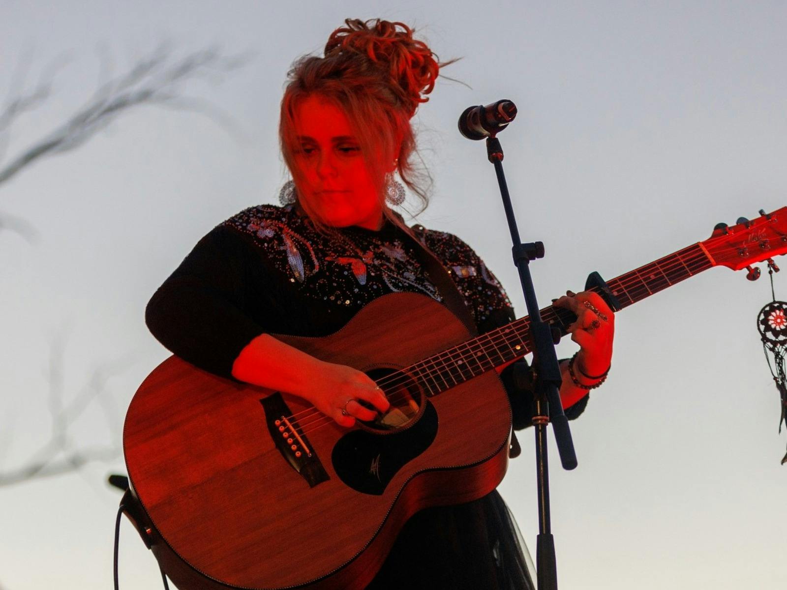 A musician performing on stage with a guitar