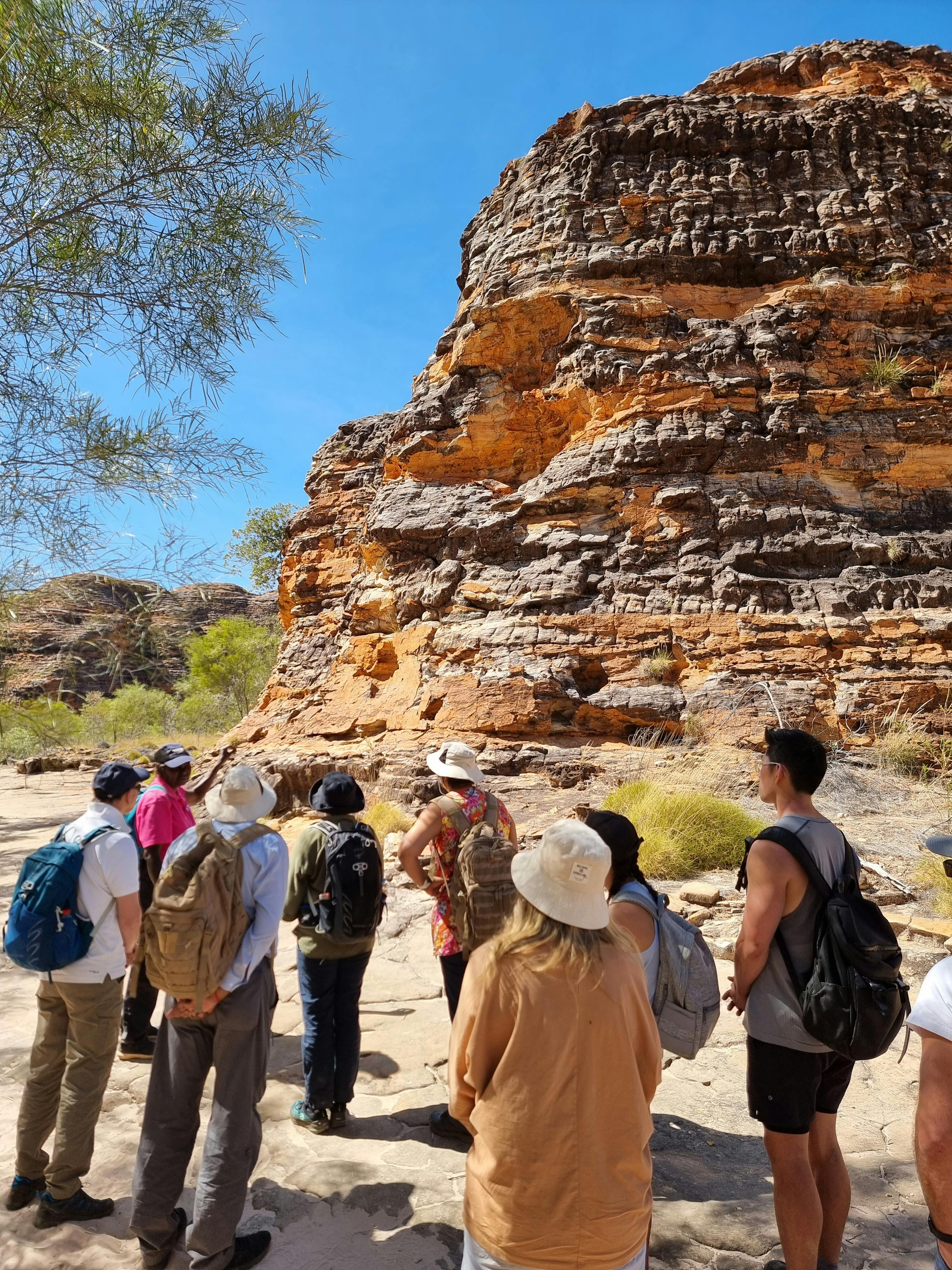 Group listening to Bec in front of a beehive dome in Purnululua