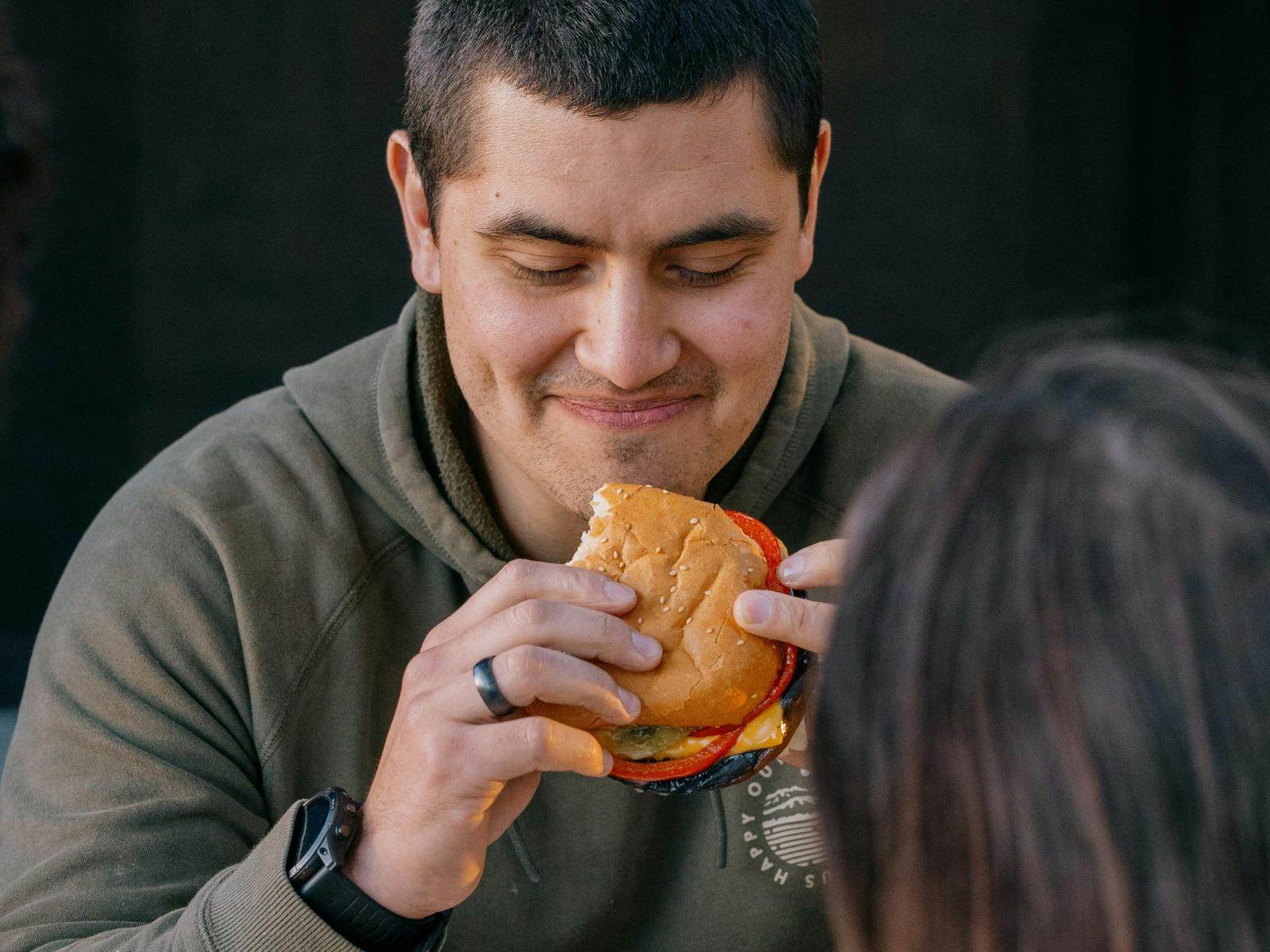 Man holding a burger at Breeze Burgers, Easy Tiger, St Helens.