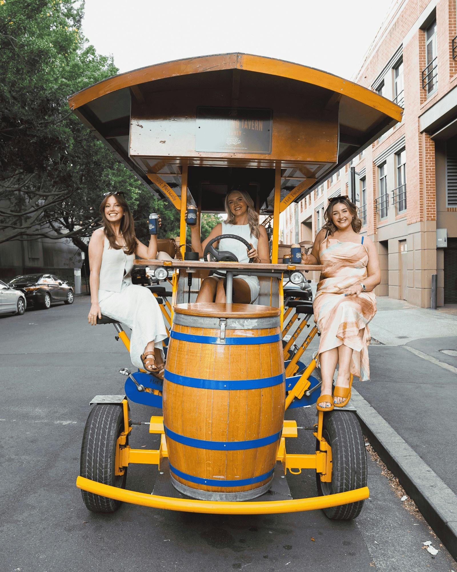 Group of girls celebrating with drinks on the Travelling Tavern bike ride through the city