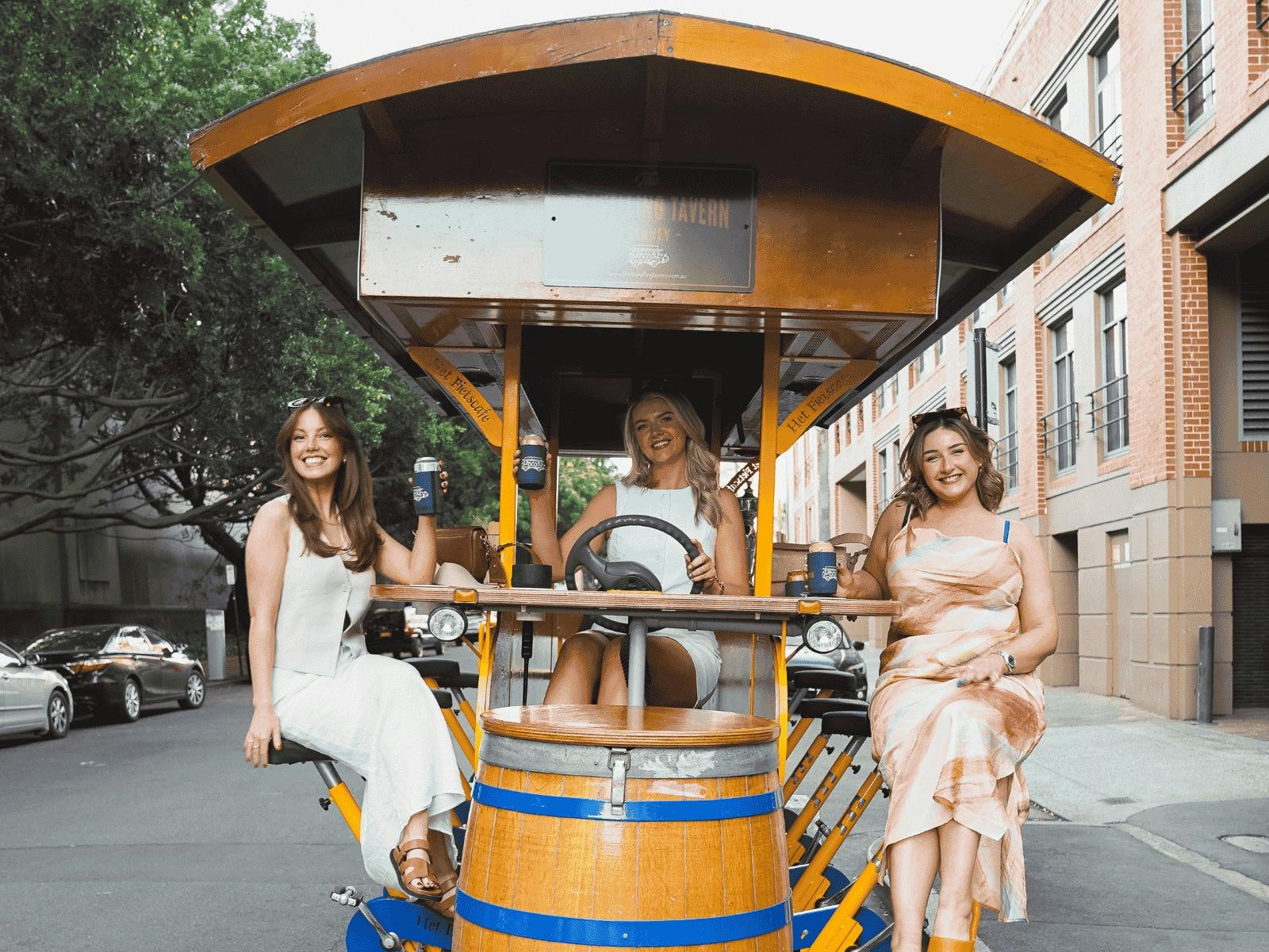 Group of girls celebrating with drinks on the Travelling Tavern bike ride through the city