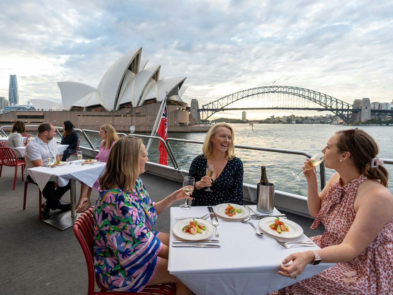 Guests dining on a lunch cruise in Sydney with the Opera House and Harbour Bridge as the backdrop