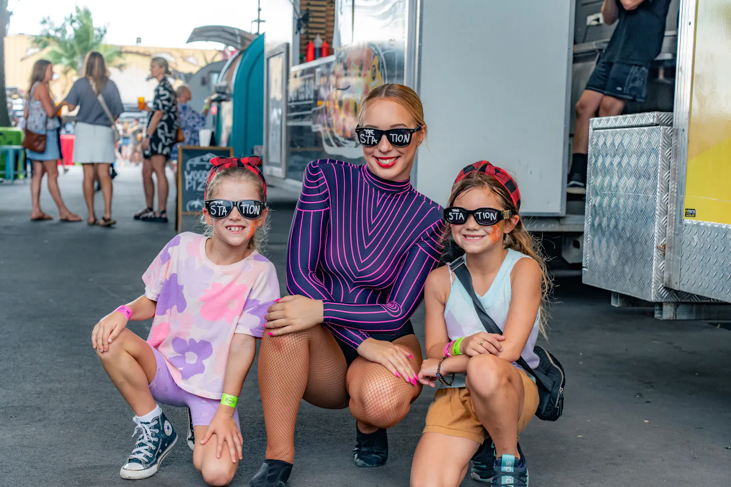 Entertainer with two children wearing funny glasses; everyone is happy