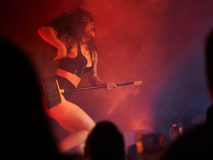 Sydney burlesque dancer rocks out with a broom as an air guitar and sexy black lingerie