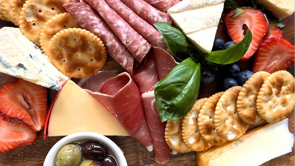 Charcuterie board of cheese, crackers and sliced meats