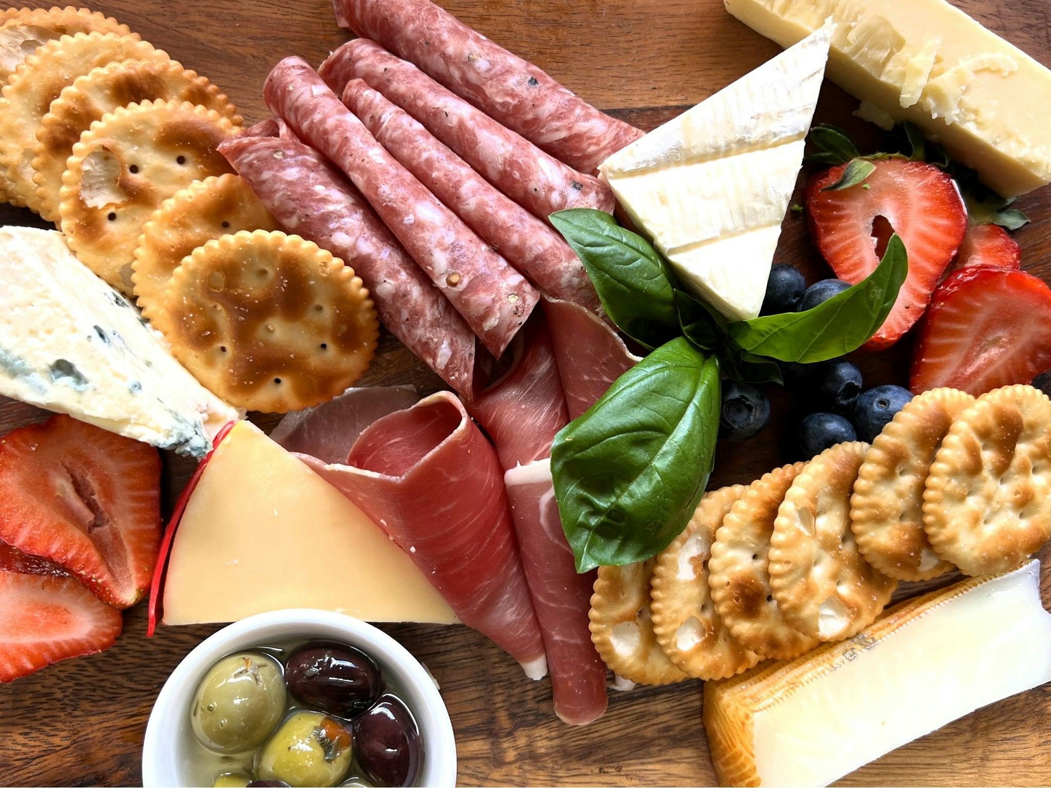Charcuterie board of cheese, crackers and sliced meats Charcuterie board of cheese, crackers and sliced meats