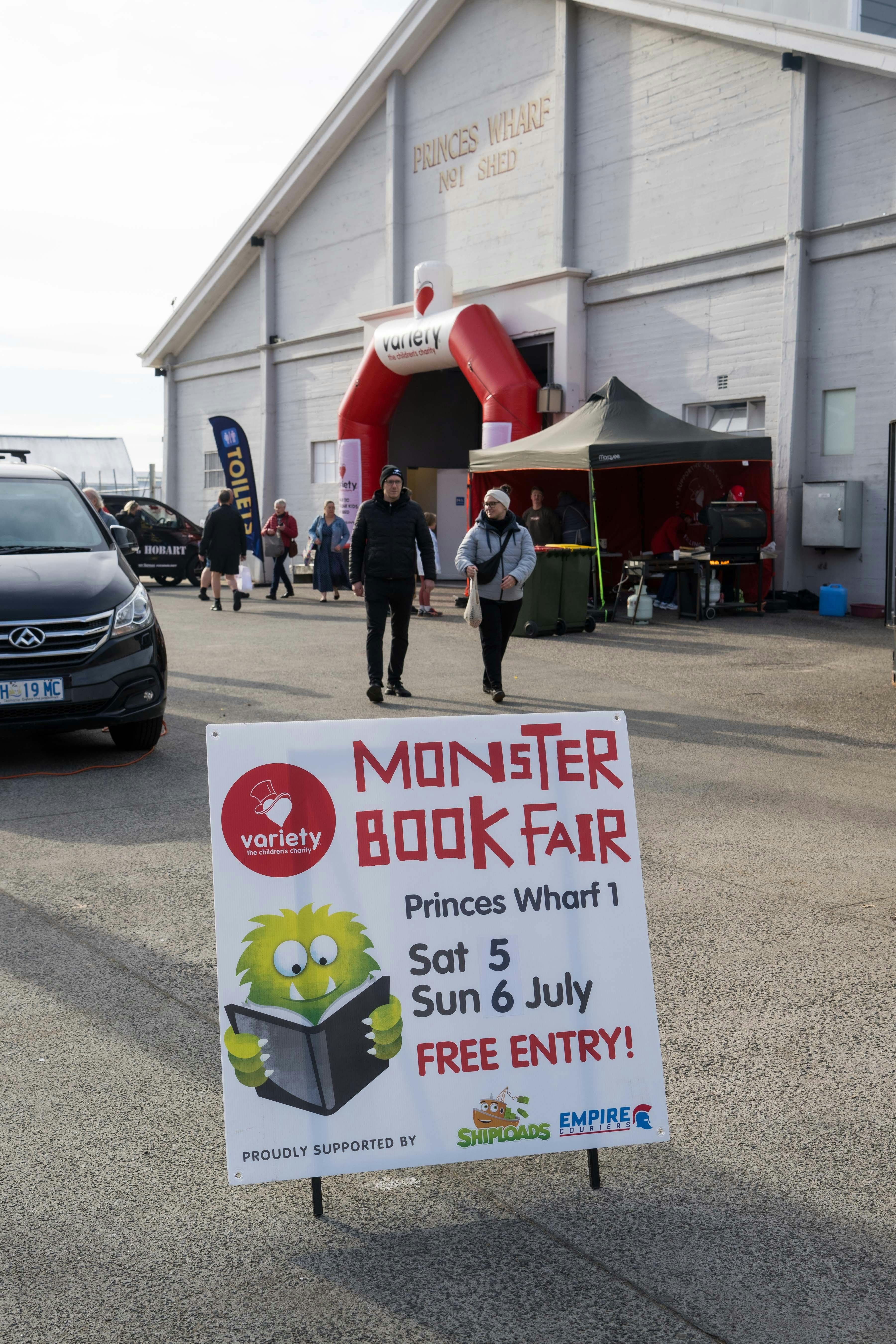 outside of PW1 in Hobart's waterfront with Variety blow up entrance and Monster Bookfair sign