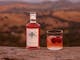 Swiftcrest Distillery strawberry gin bottle and a cocktail glass with fresh strawberries