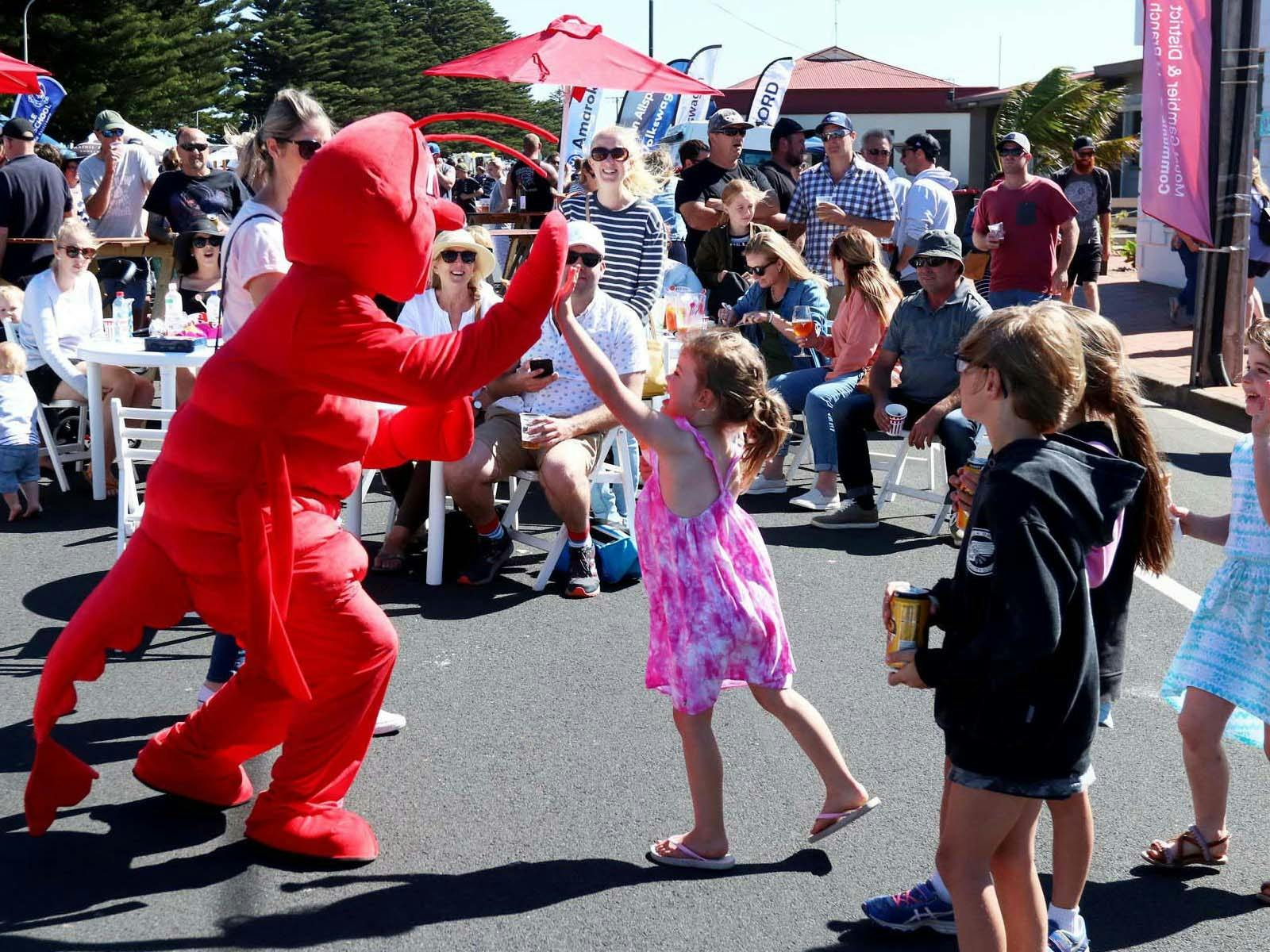 Jay the Cray mascot high fiving young girl at Bay Festival in PortMacDonnell