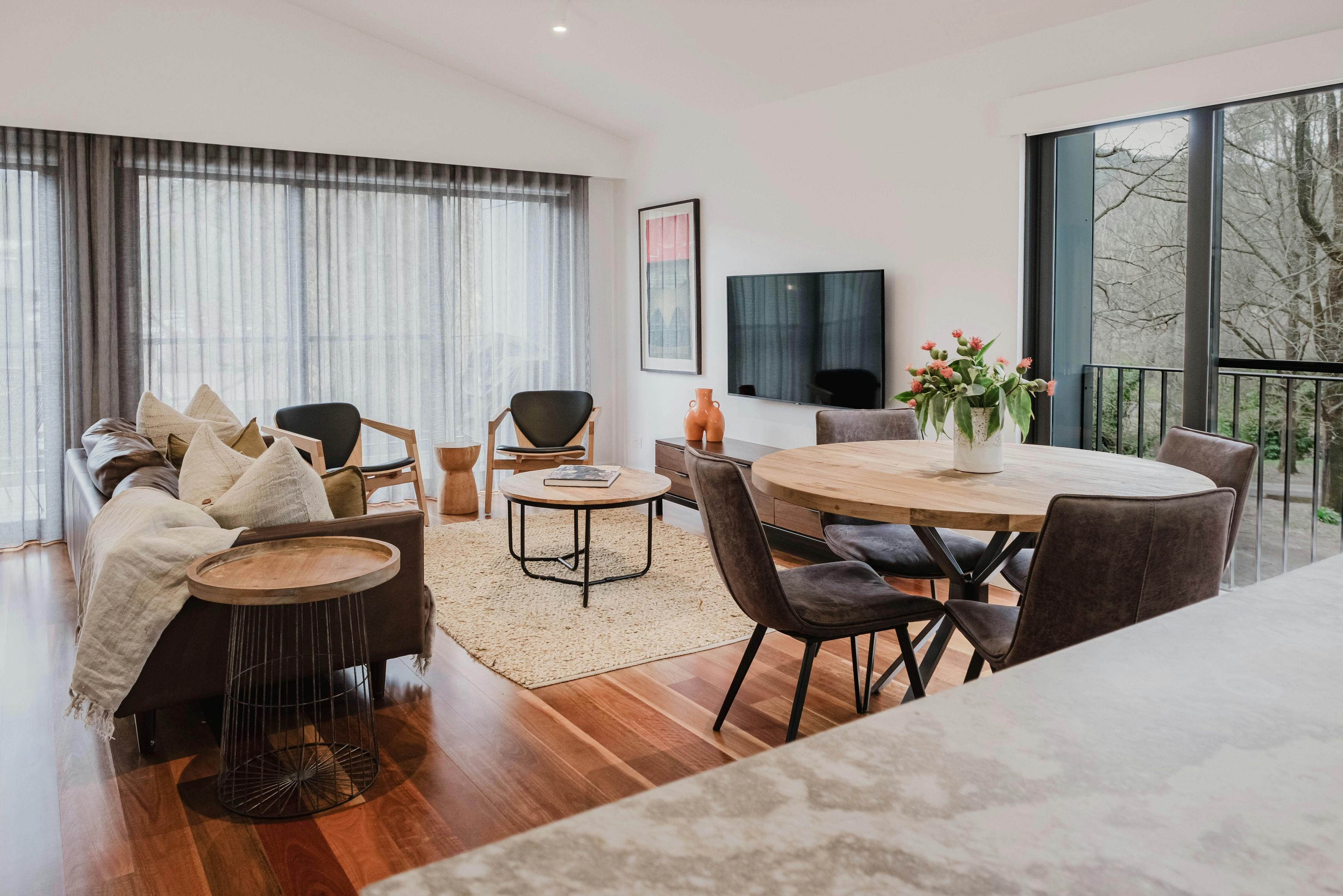 Reed arthouse townhouse living room with couch, chairs, television and dining area