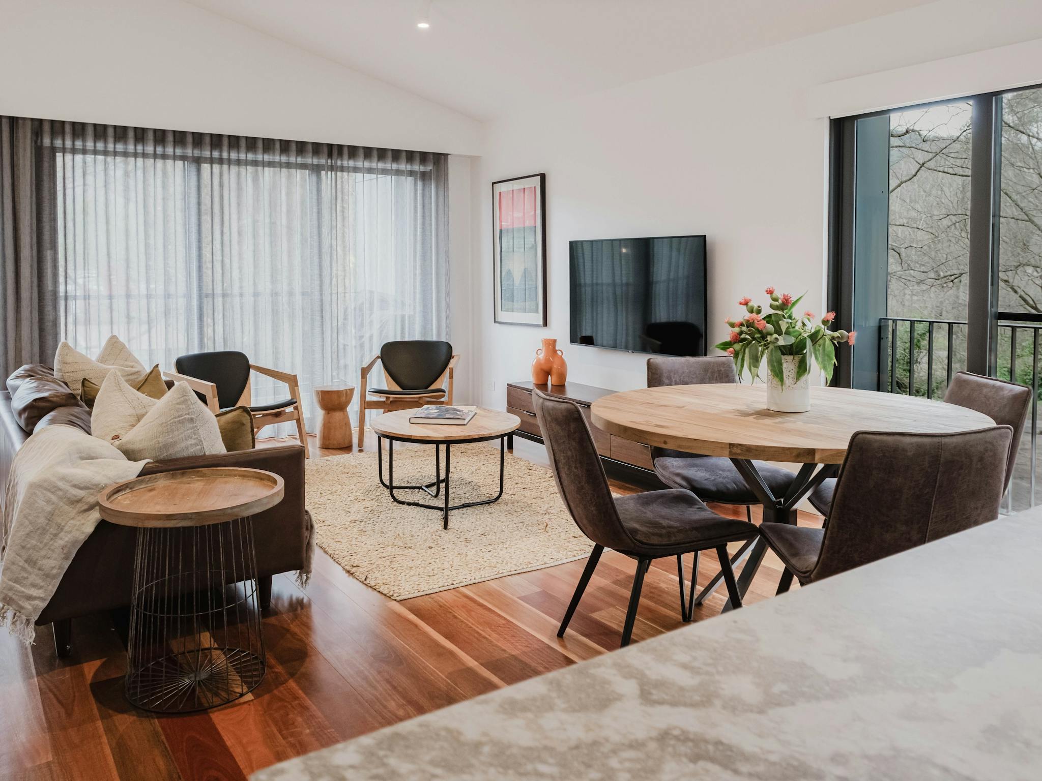 Reed arthouse townhouse living room with couch, chairs, television and dining area