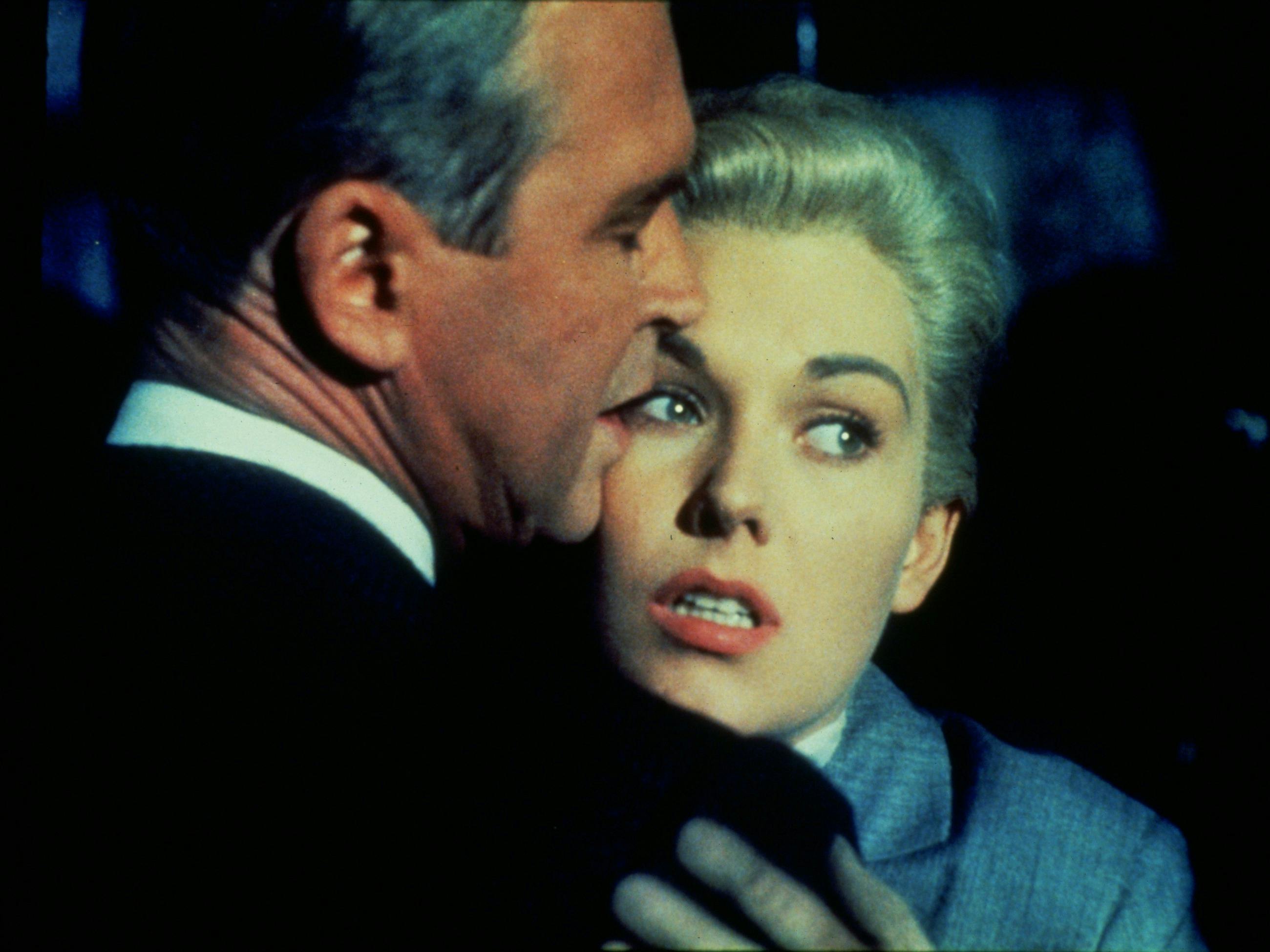 Man and woman embracing, woman faces audience, man faces away from camera