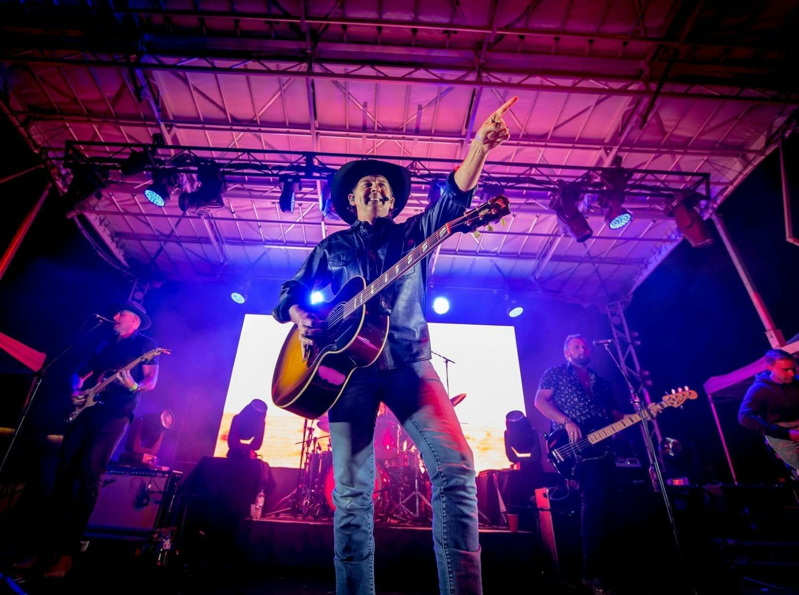 Lee Kernaghan playing guitar on stage