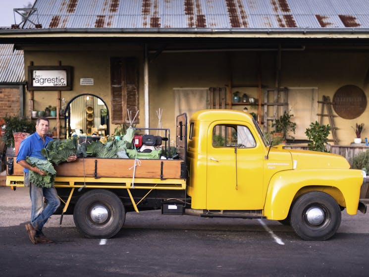 Local producer making a delivery to Agrestic with canary yellow vintage truck laiden with produce.