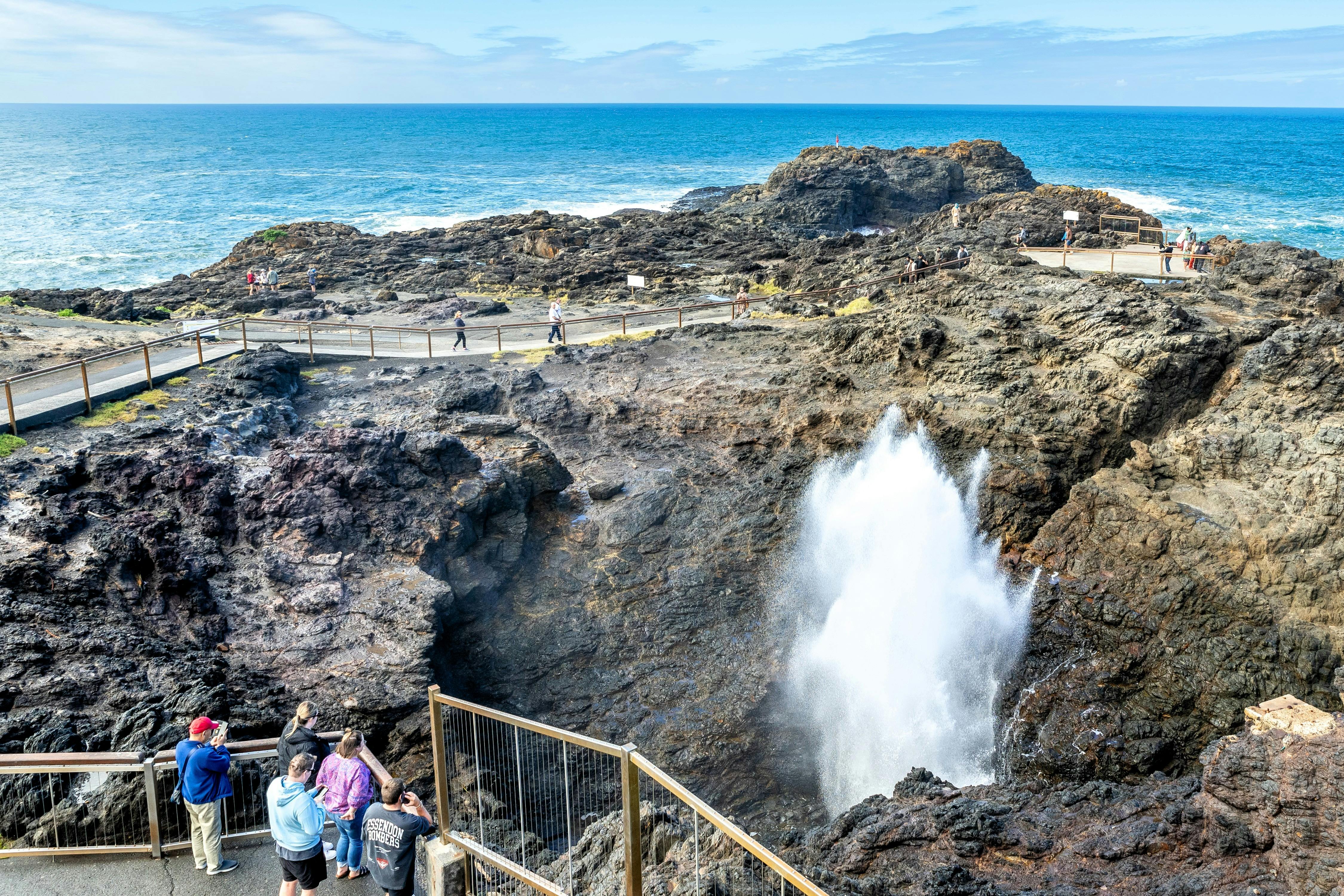 People watch as water gushes up at Kiama Blowhole