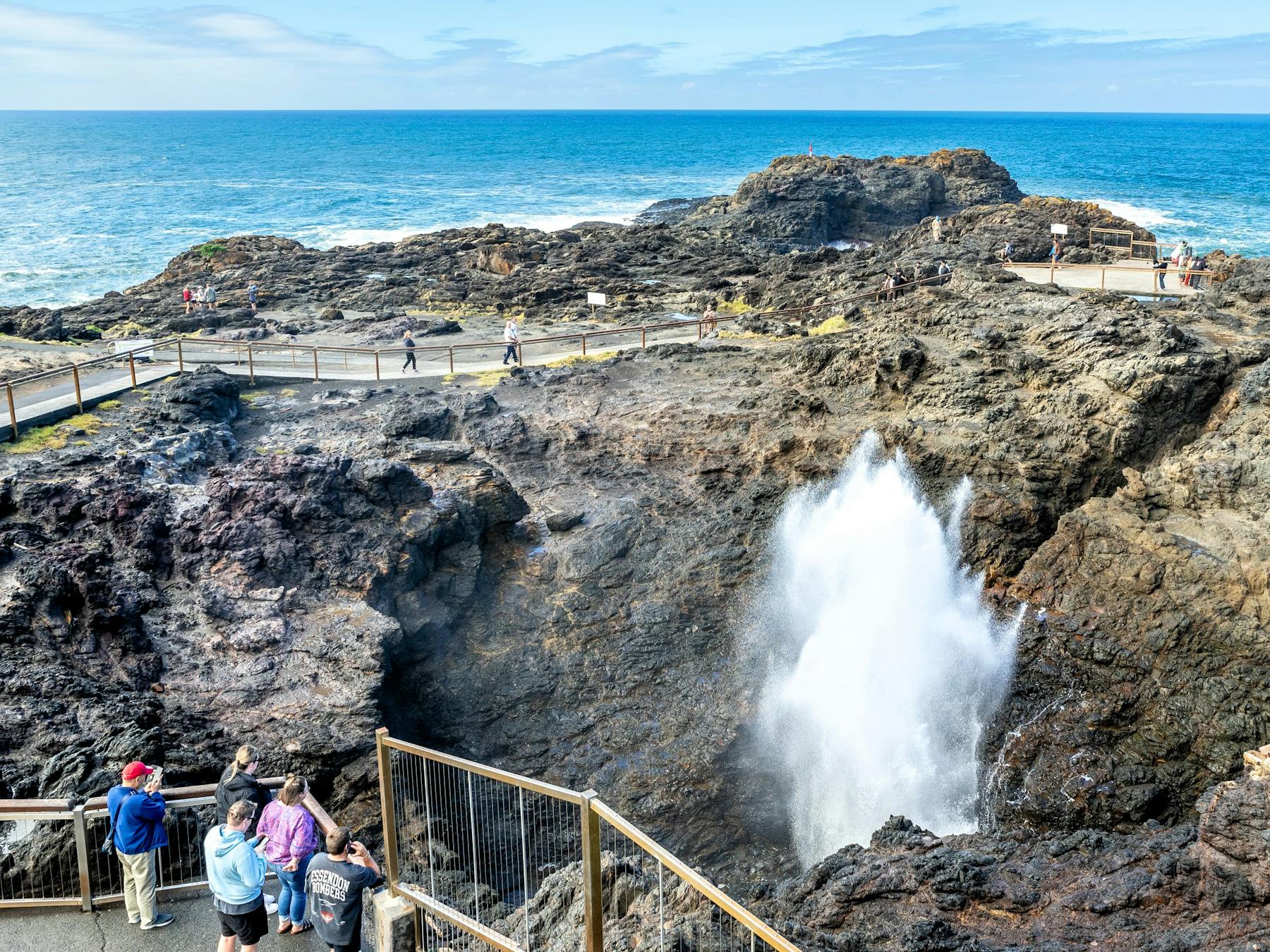 People watch as water gushes up at Kiama Blowhole