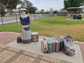 This artwork depicts an iconic pioneer woman Dulcie, waiting with luggage to board a train