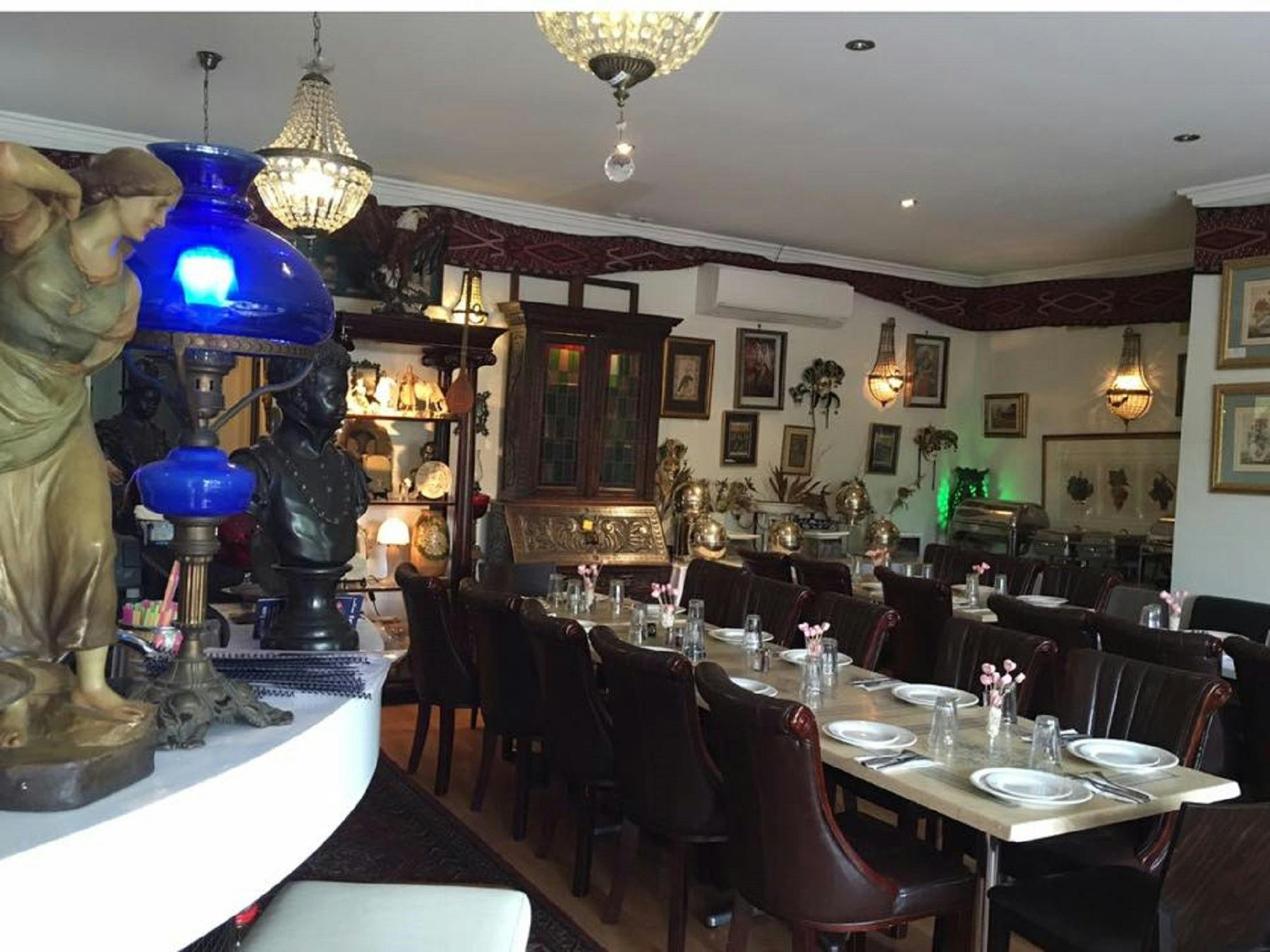 Empty restaurant setting with cutlery and crockery laid out on table