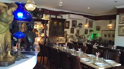 Empty restaurant setting with cutlery and crockery laid out on table