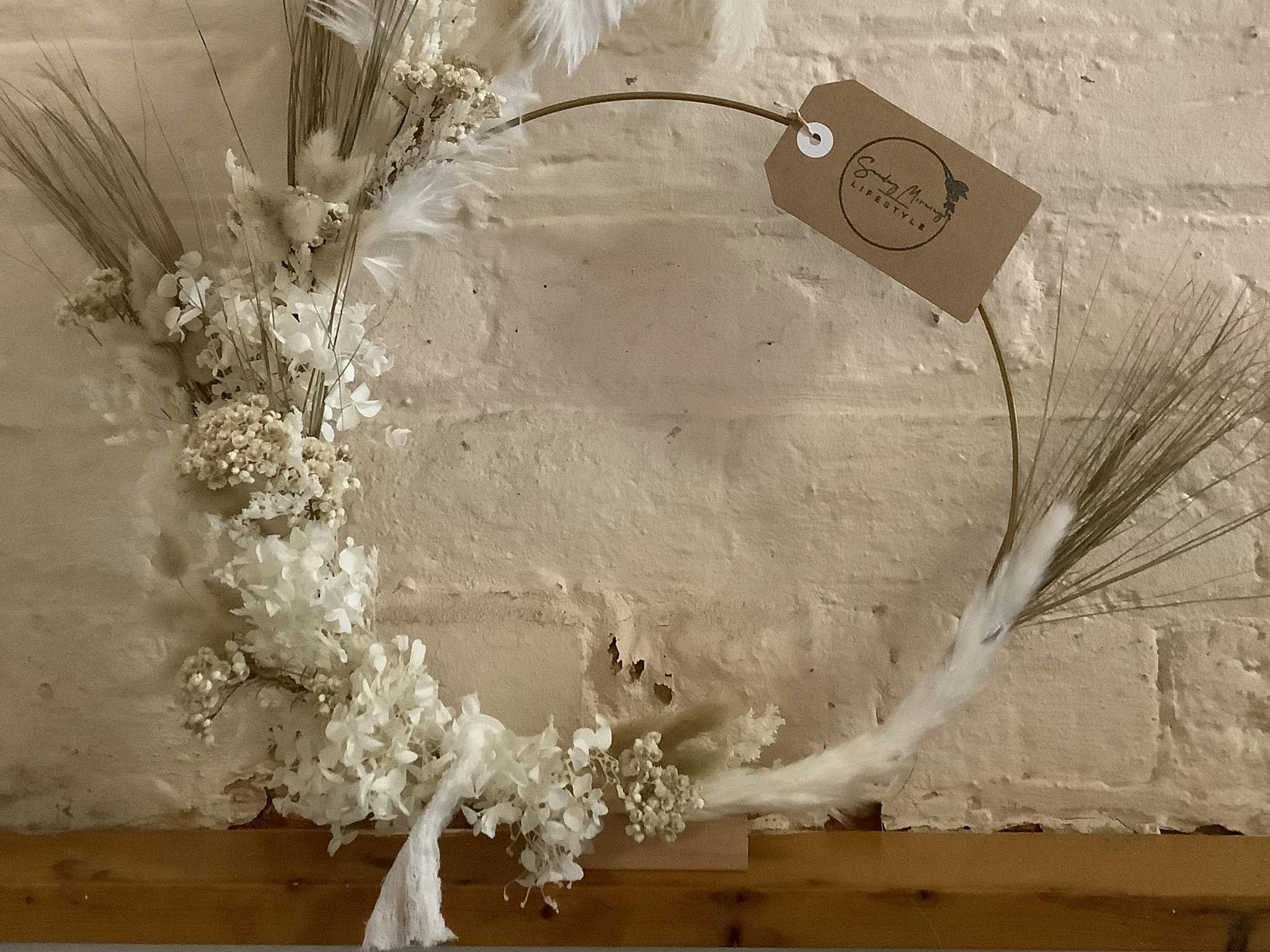 Free standing, dried flower wreath in neutral tones.