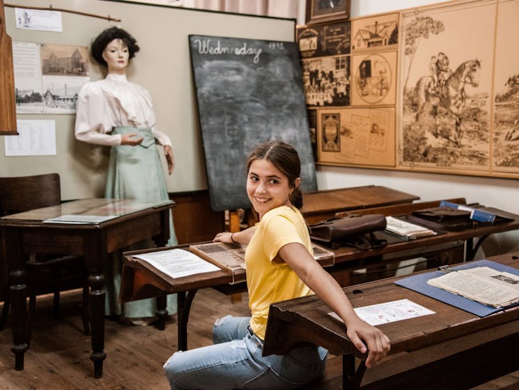 young girl sitting in old school house display at the Federation Museum Corowa