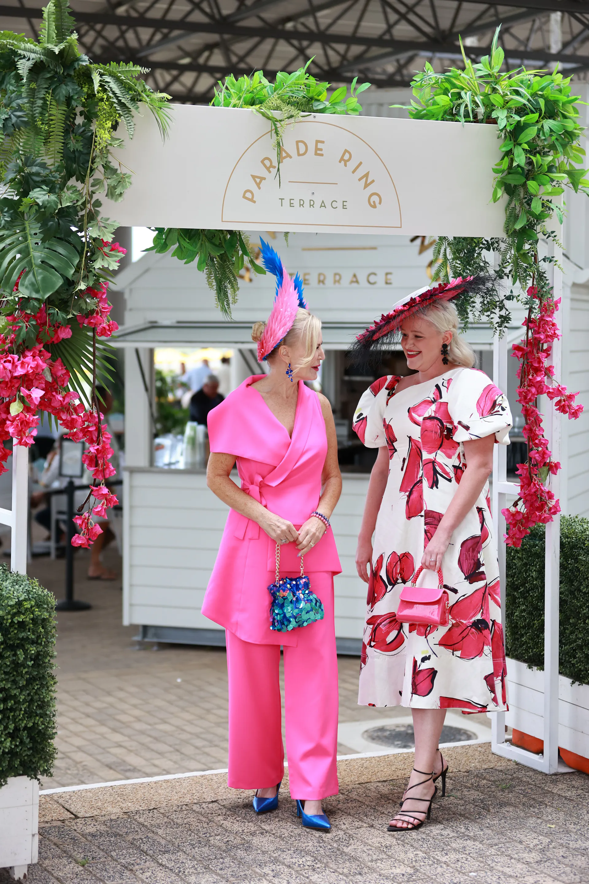 two ladies in front of parade ring terrace talking to each other