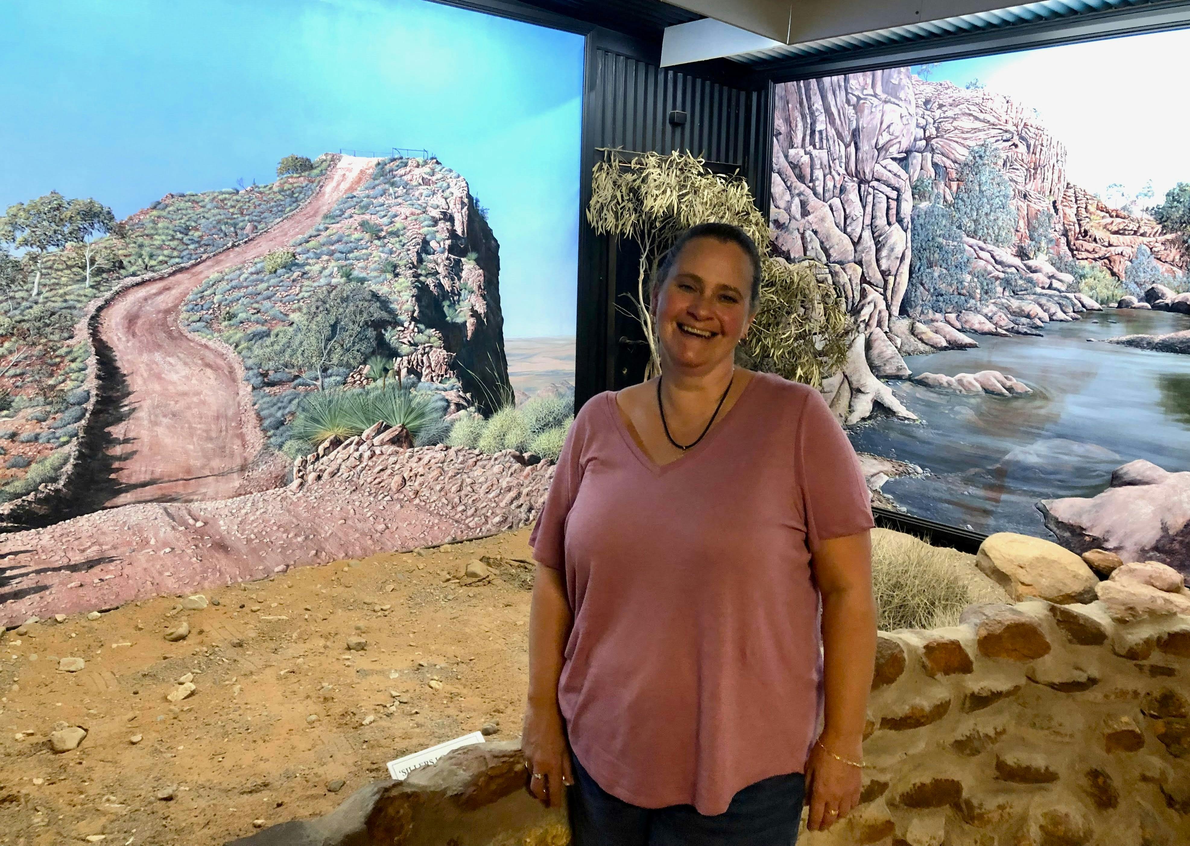 Woman standing in front of two large paintings
