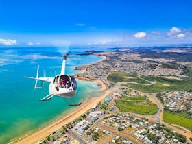 Photo of Yeppoon Central Queensland showing town and coastline with a helicopter