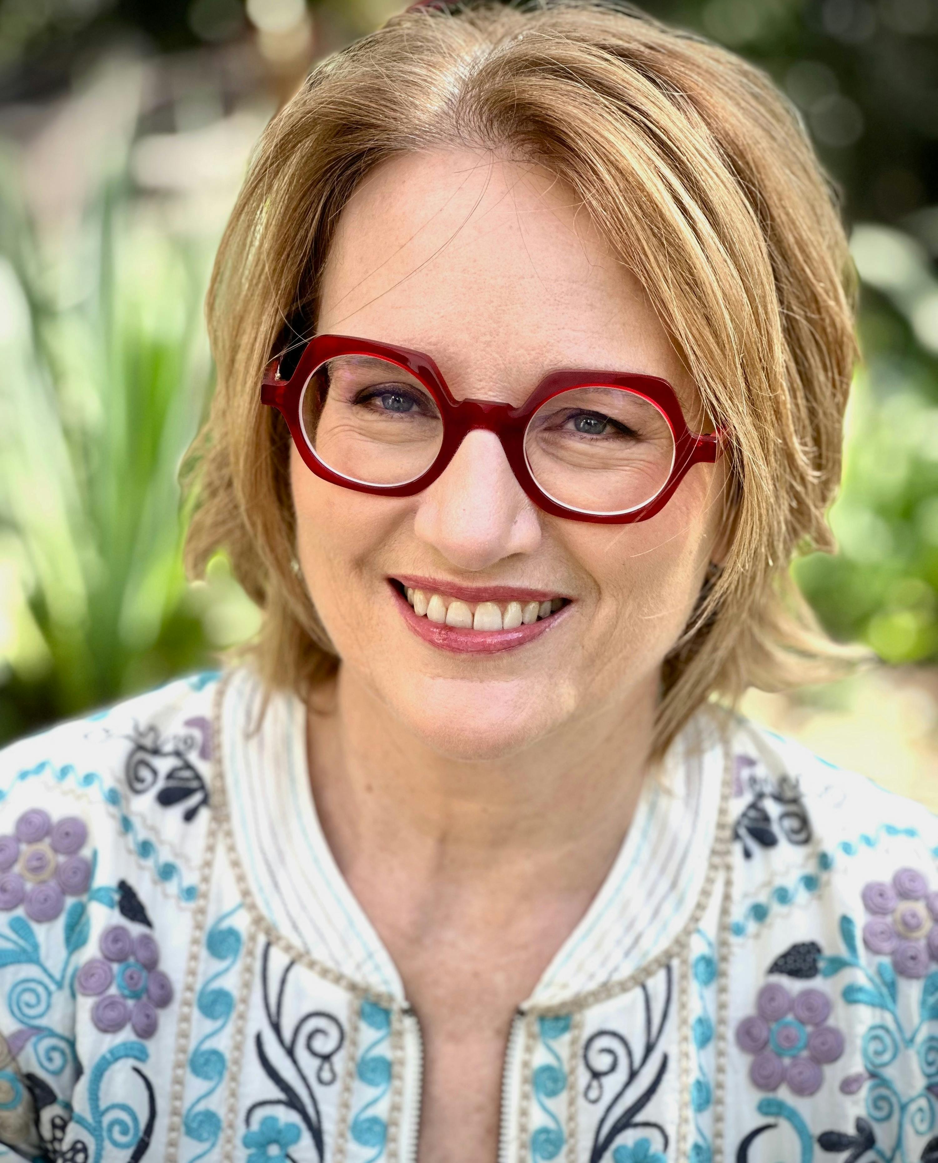 Smiling lady with red rimmed glasses