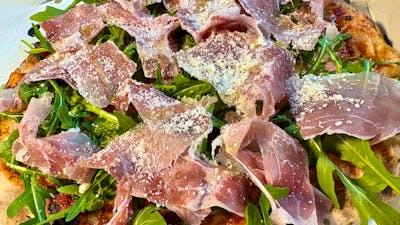 Primavera pizza with rocket and Italian prosciutto and parmesan cheese