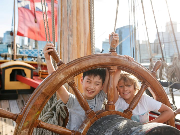 Kids at the wheel of the ship Endeavour