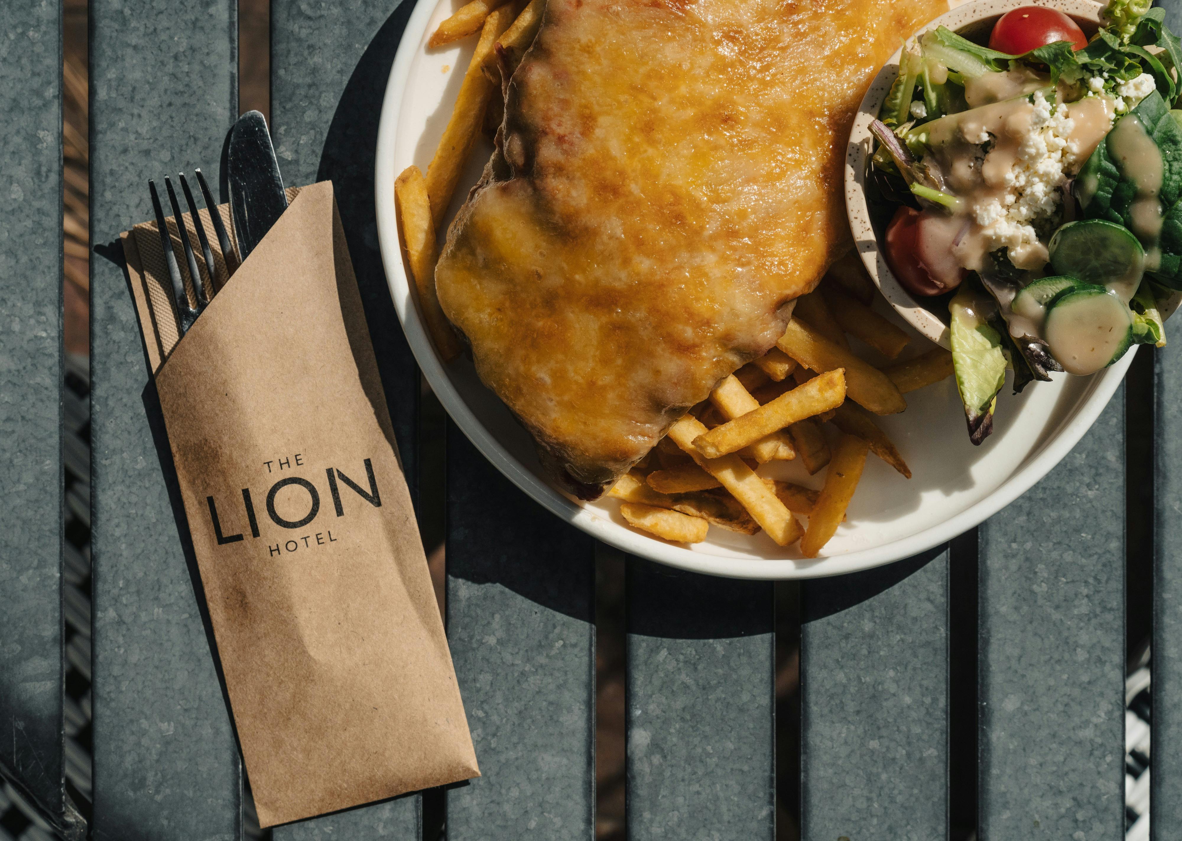 A hearty schnitzel meal served with a crisp salad and golden fries at the Lion Hotel.