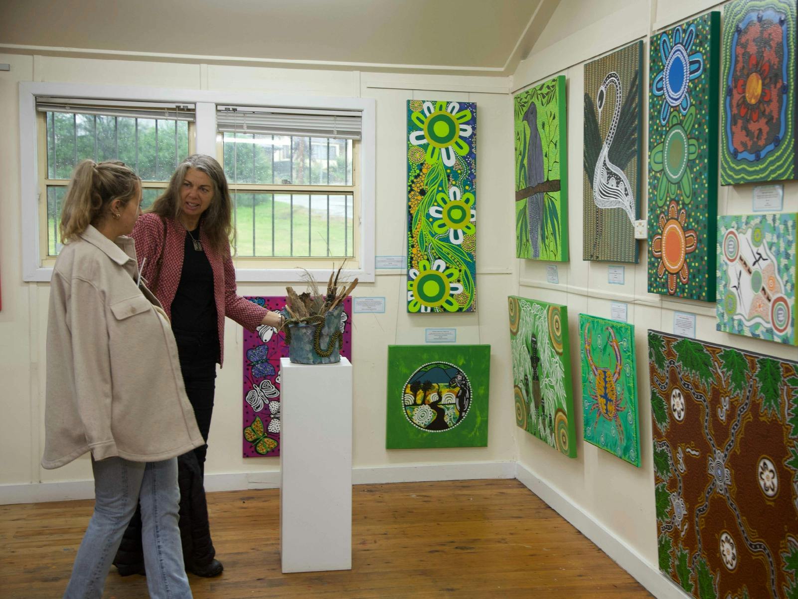 Two women viewing artwork in an art gallery