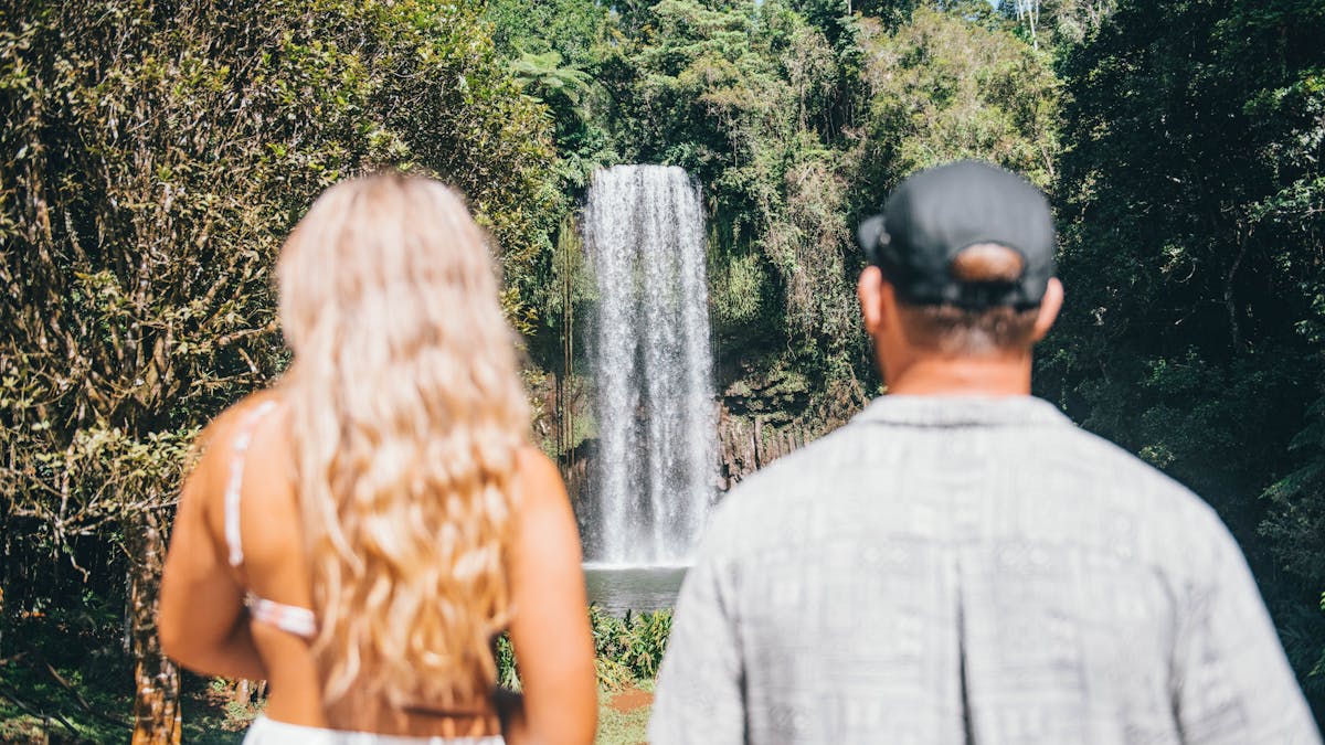 Couple stands with their backs to the camera as the stare at Millaa Millaa on Atherton Tablelands
