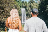 Couple stands with their backs to the camera as the stare at Millaa Millaa on Atherton Tablelands