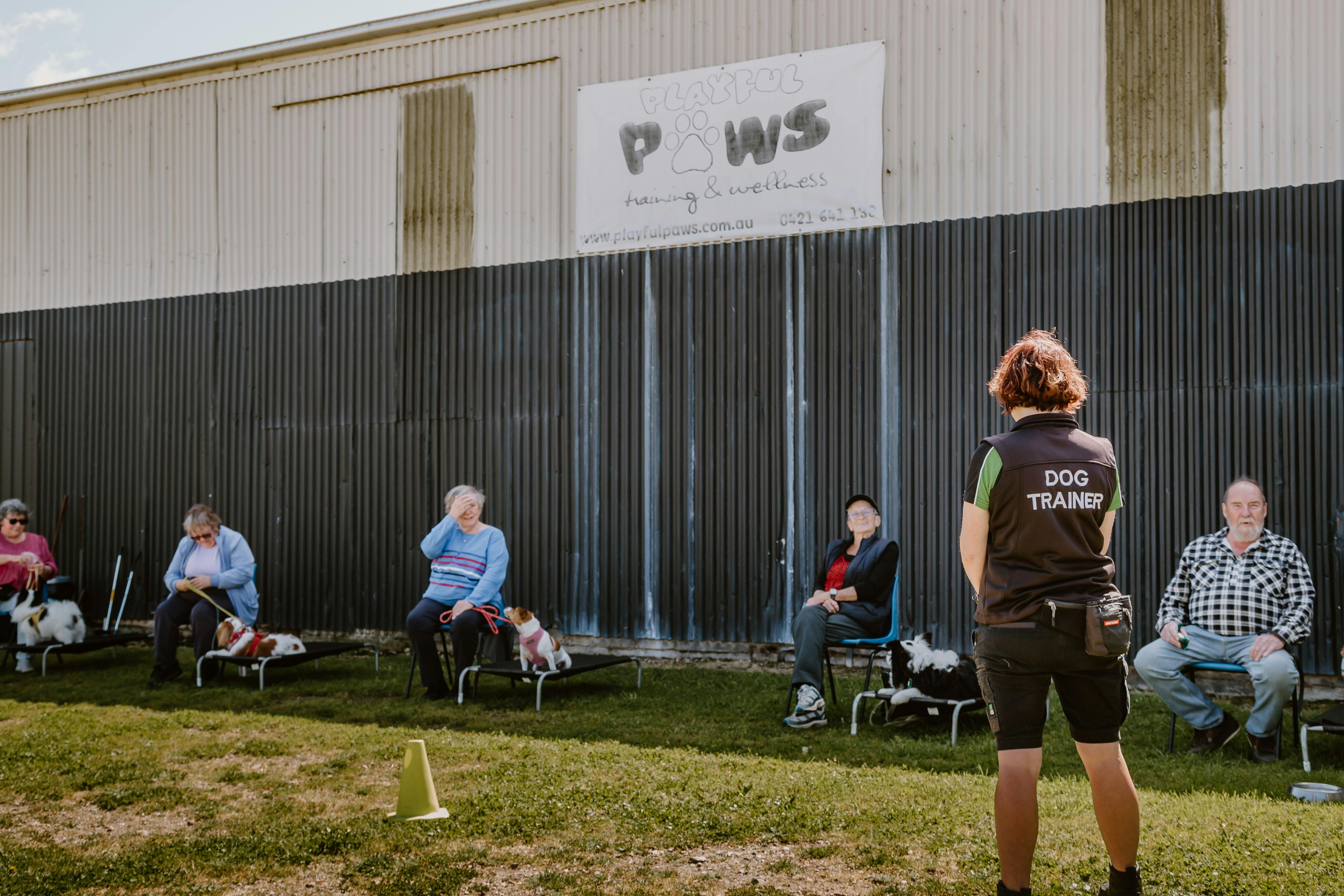 Dog trainer speaking to people at Playful Paws
