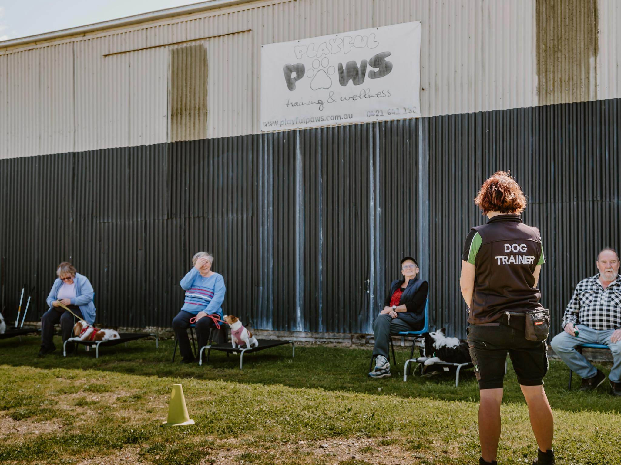 Dog trainer speaking to people at Playful Paws