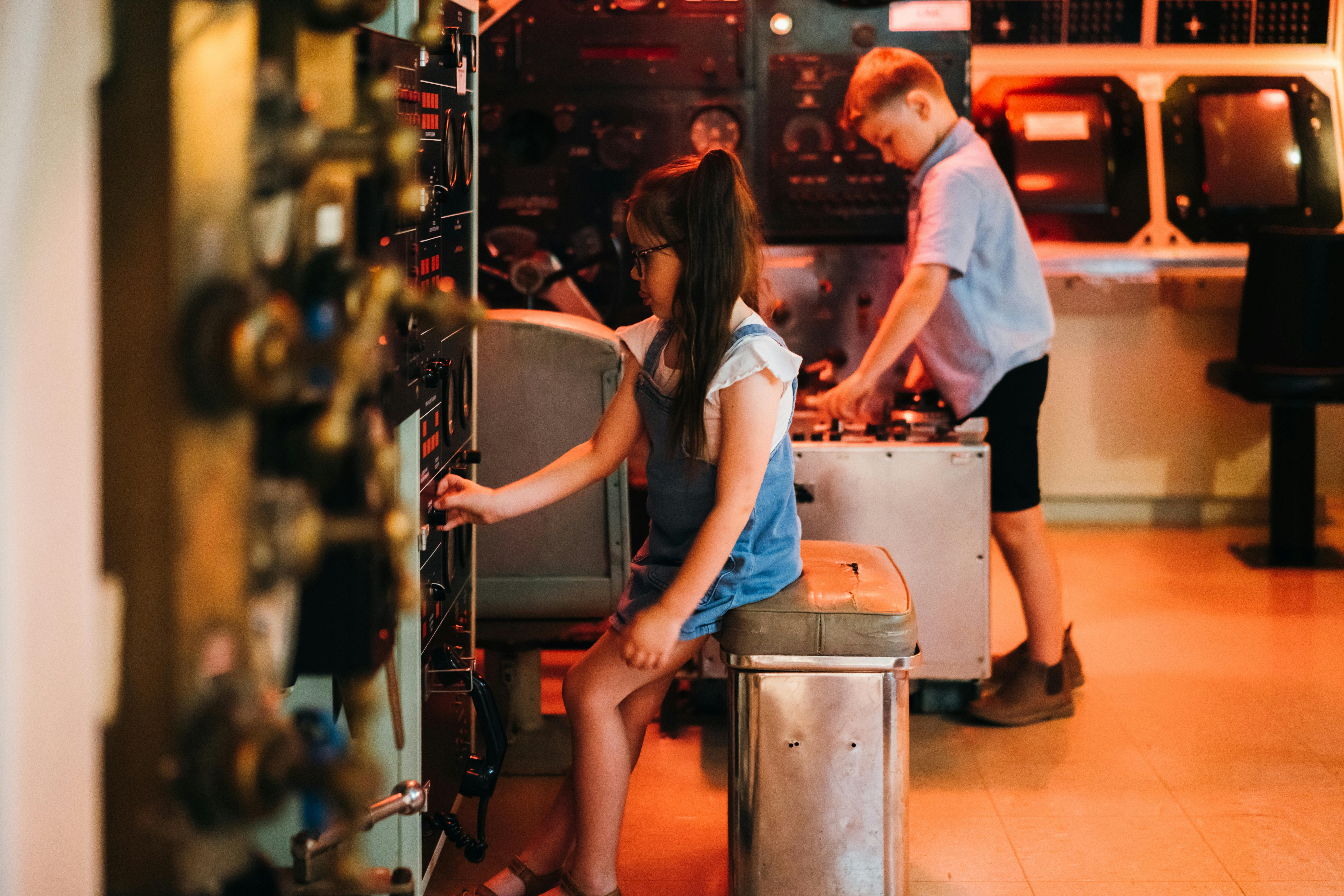 Boy and girl playing in the control room of the submarine