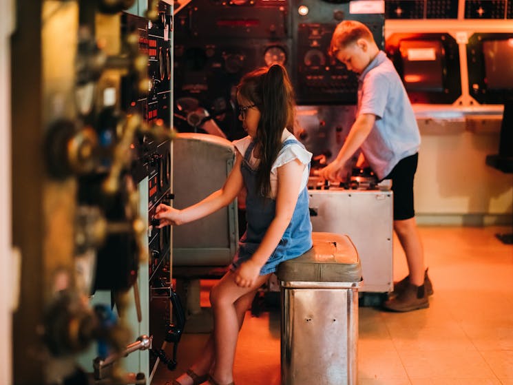 Boy and girl playing in the control room of the submarine