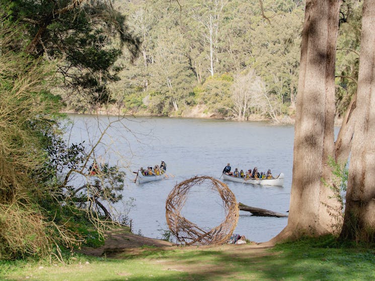 An art installation with canoes in the background